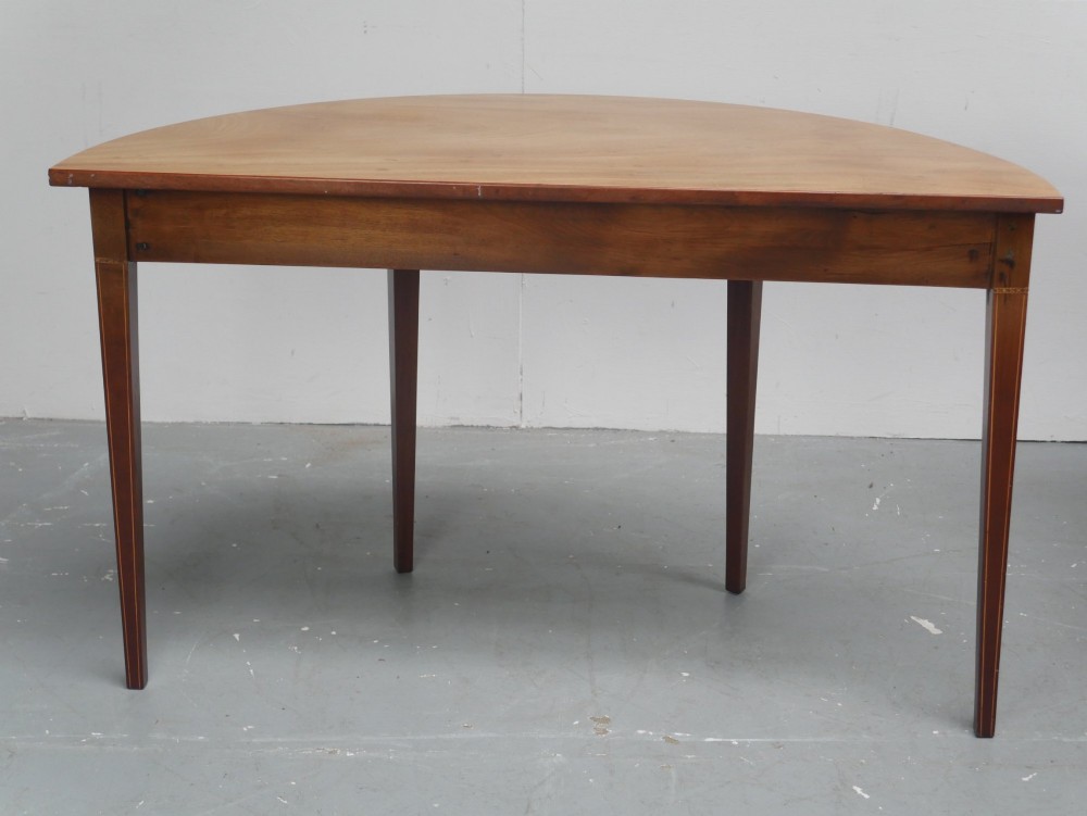 A Regency mahogany demi-lune console table featuring satinwood stringing inlay, a central drawer, and four square tapered legs. View VII