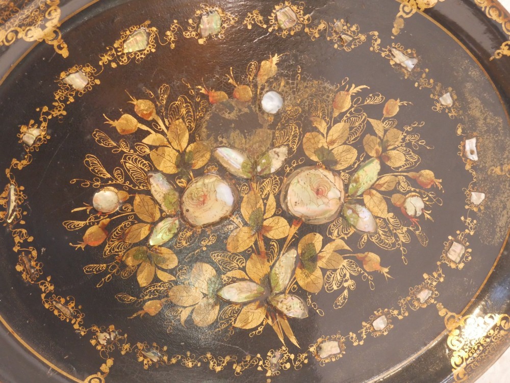 An oval black lacquered papier-mache tray decorated with gilt floral scrollwork and iridescent mother-of-pearl inlay. View II