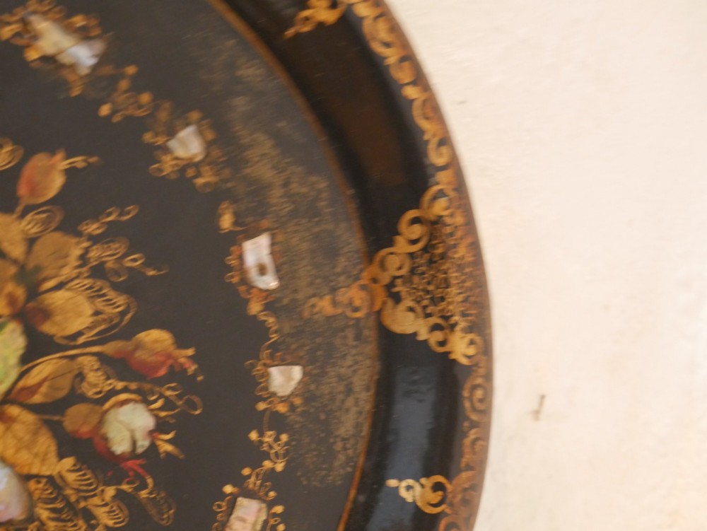 An oval black lacquered papier-mache tray decorated with gilt floral scrollwork and iridescent mother-of-pearl inlay. View III