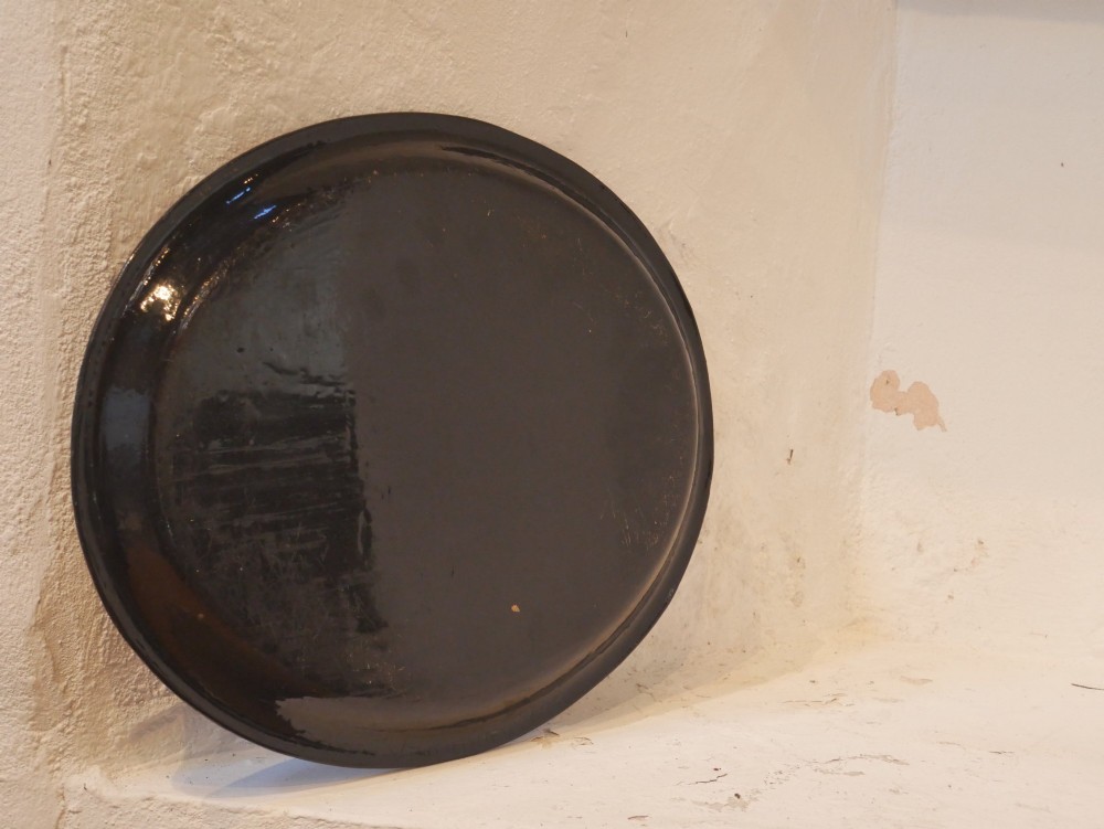 An oval black lacquered papier-mache tray decorated with gilt floral scrollwork and iridescent mother-of-pearl inlay. View V
