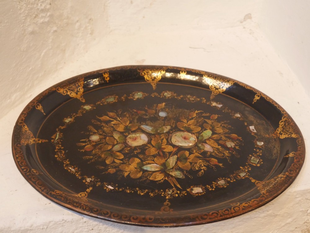 An oval black lacquered papier-mache tray decorated with gilt floral scrollwork and iridescent mother-of-pearl inlay. View VI