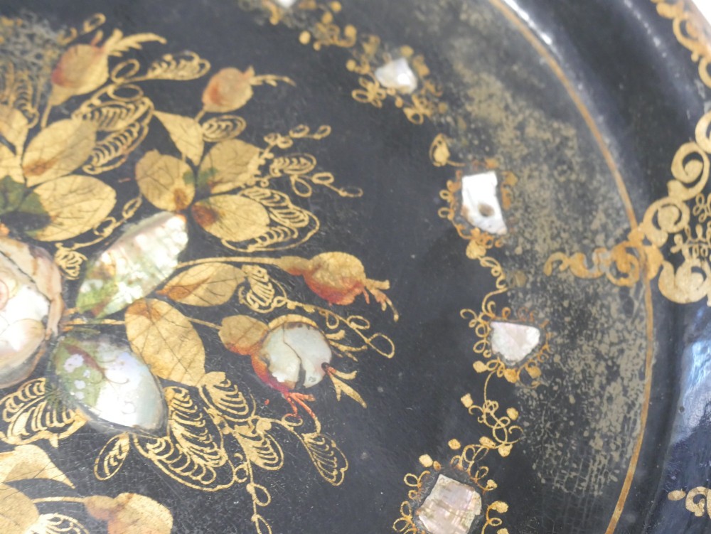An oval black lacquered papier-mache tray decorated with gilt floral scrollwork and iridescent mother-of-pearl inlay. View IX