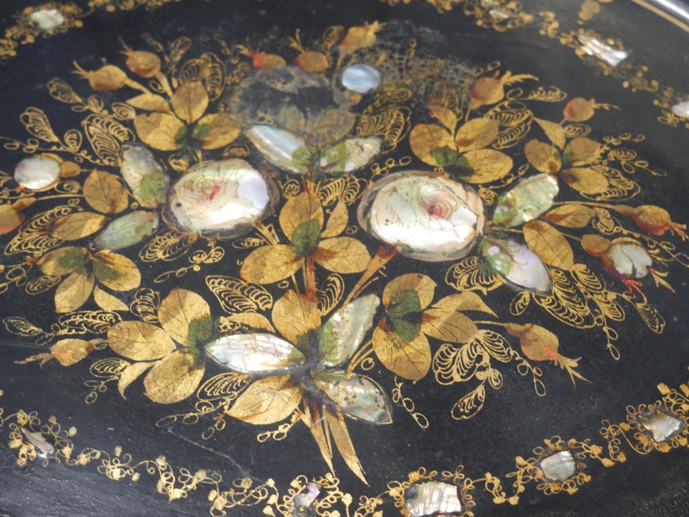 An oval black lacquered papier-mache tray decorated with gilt floral scrollwork and iridescent mother-of-pearl inlay. View XI