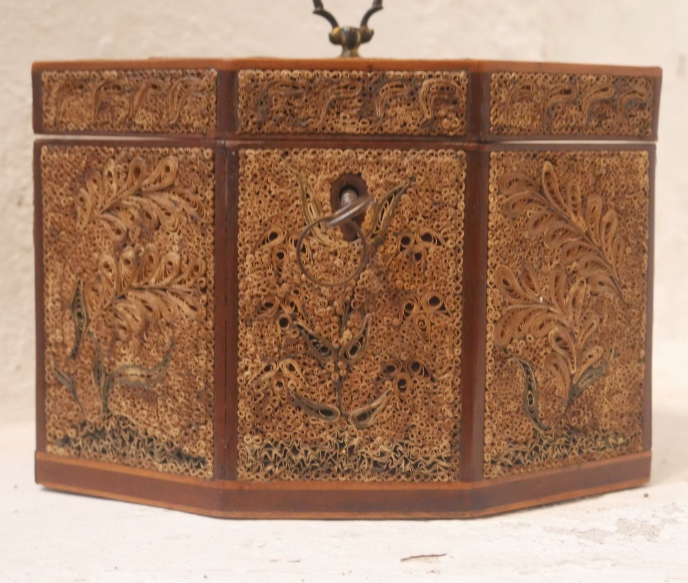 An 18th-century octagonal wooden tea caddy featuring intricate paper filigree quilling, foliate designs, a top brass loop handle, and a key. View III