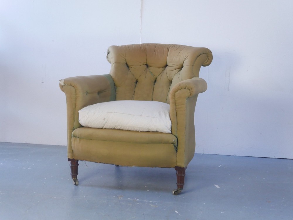 A 19th-century Victorian armchair upholstered in olive fabric with a button-backed scroll back, turned timber front legs on brass castors, and a fitted seat cushion. View III