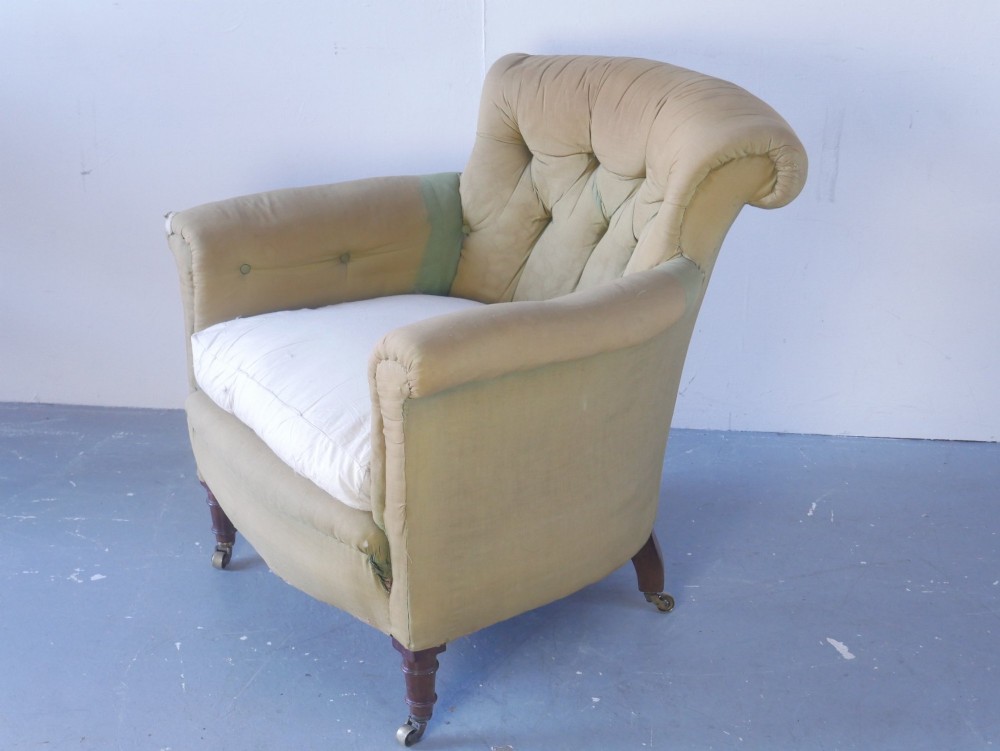 A 19th-century Victorian armchair upholstered in olive fabric with a button-backed scroll back, turned timber front legs on brass castors, and a fitted seat cushion. View IV