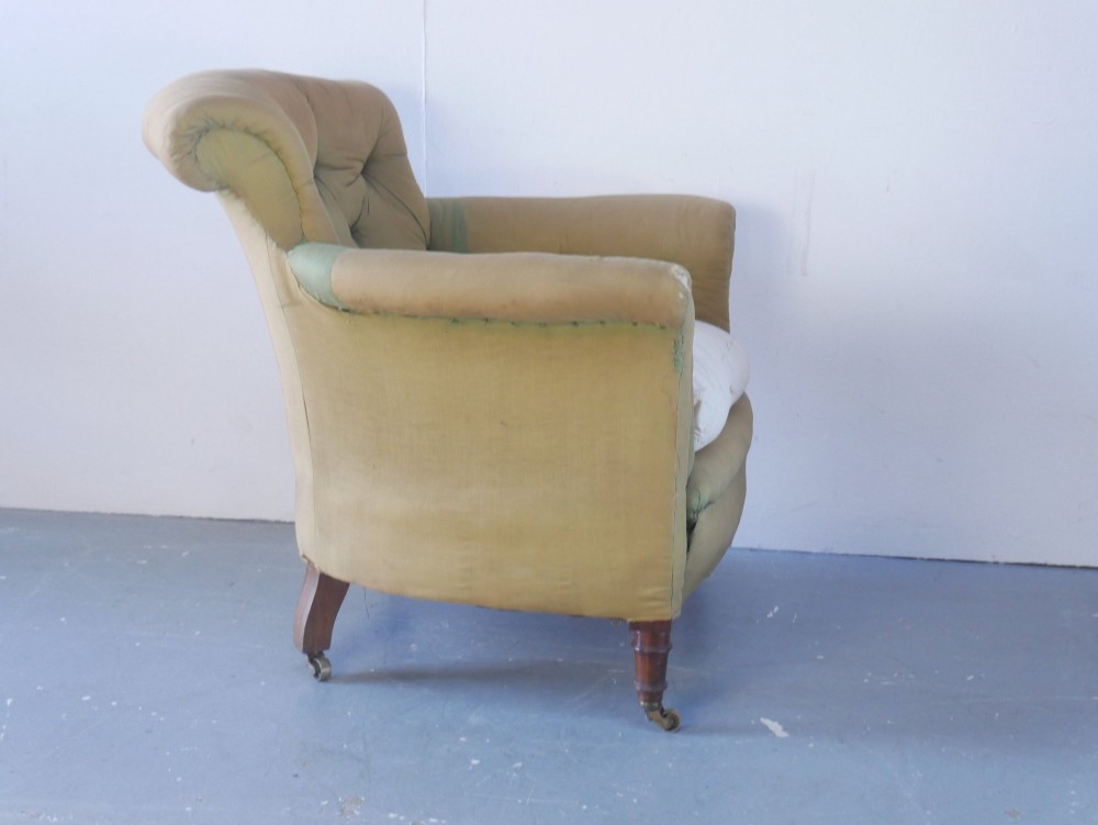 A 19th-century Victorian armchair upholstered in olive fabric with a button-backed scroll back, turned timber front legs on brass castors, and a fitted seat cushion. View VIII