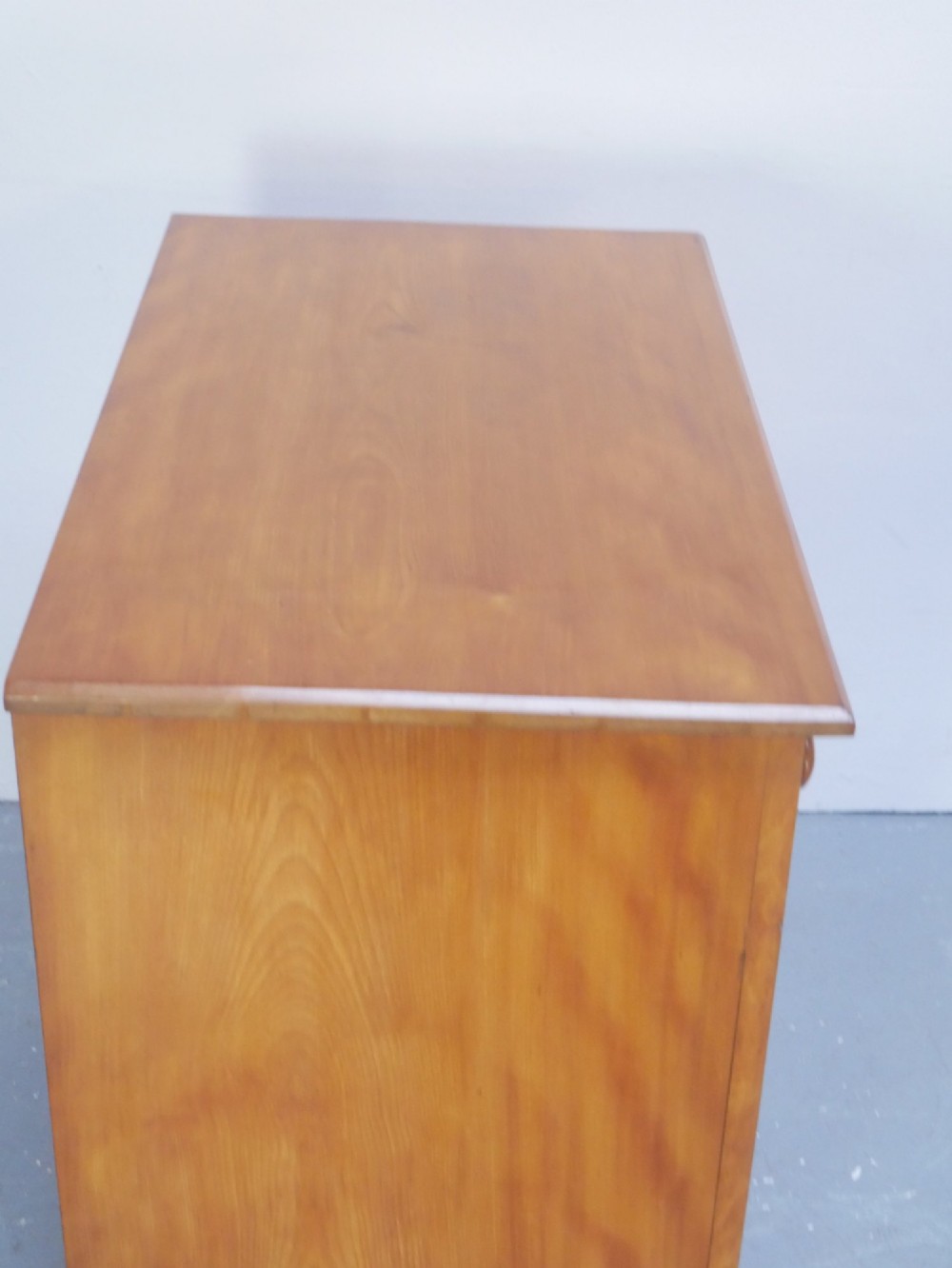 An antique Scottish wooden chest featuring four full-width drawers with dark turned handles and carved roundel details at the upper corners. View II