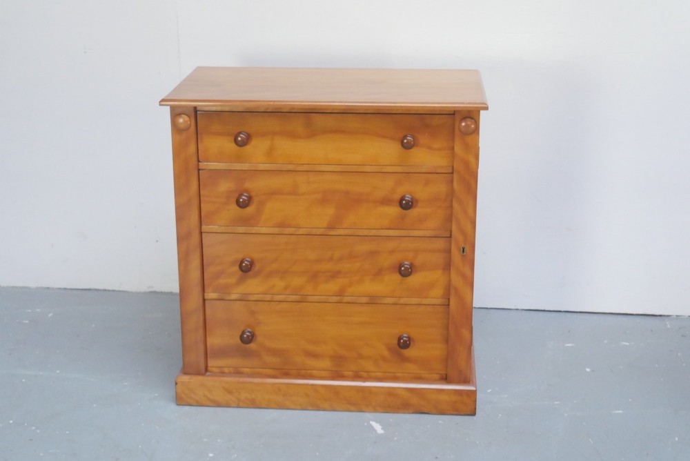 An antique Scottish wooden chest featuring four full-width drawers with dark turned handles and carved roundel details at the upper corners. View IV