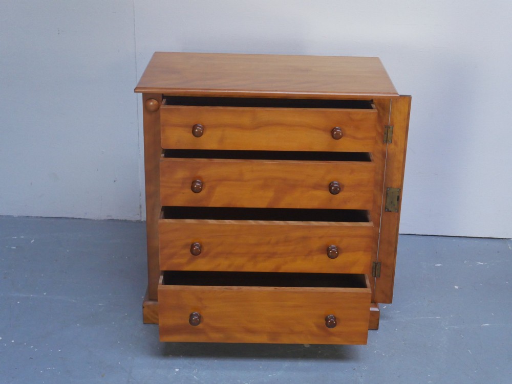 An antique Scottish wooden chest featuring four full-width drawers with dark turned handles and carved roundel details at the upper corners. View V
