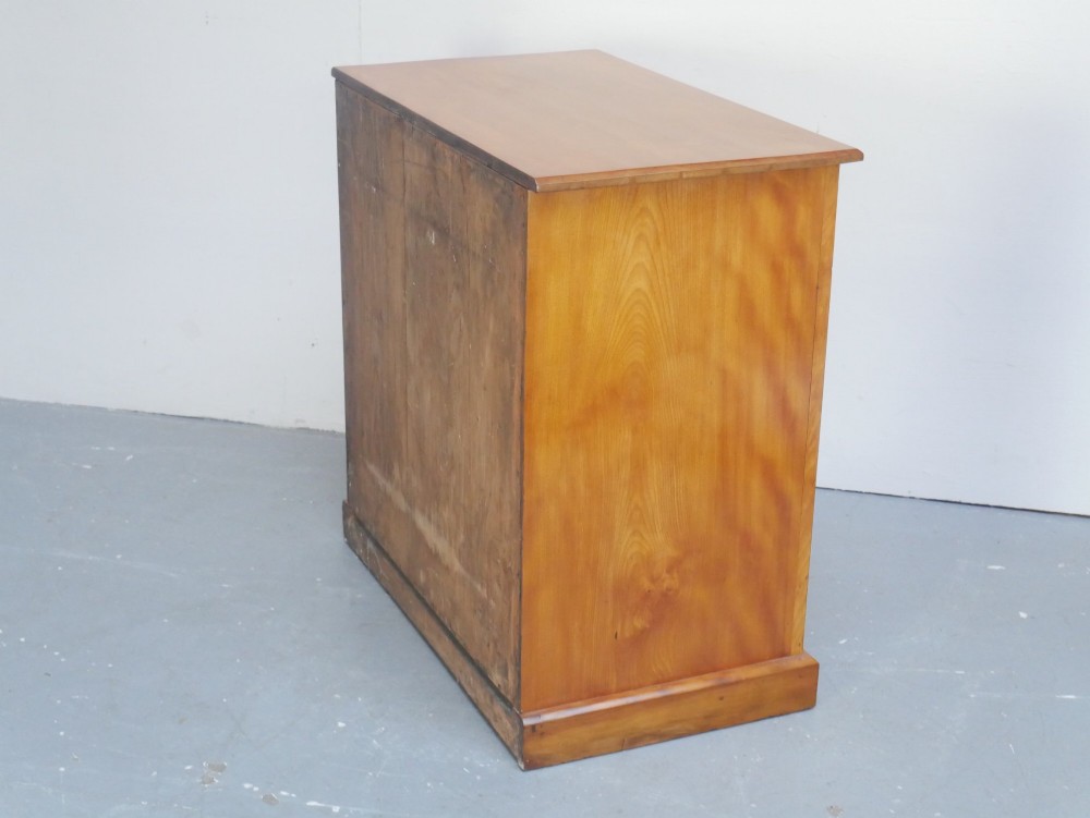 An antique Scottish wooden chest featuring four full-width drawers with dark turned handles and carved roundel details at the upper corners. View VII