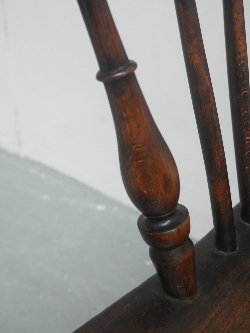 A dark brown wooden Windsor armchair featuring a rounded hoop back, vertical spindles, turned legs, and an H-stretcher. View VII