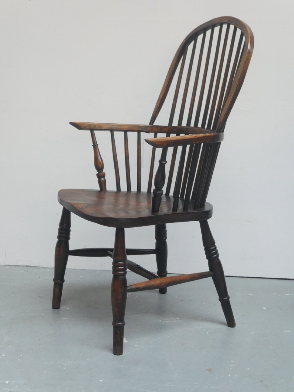 A dark brown wooden Windsor armchair featuring a rounded hoop back, vertical spindles, turned legs, and an H-stretcher. View VIII