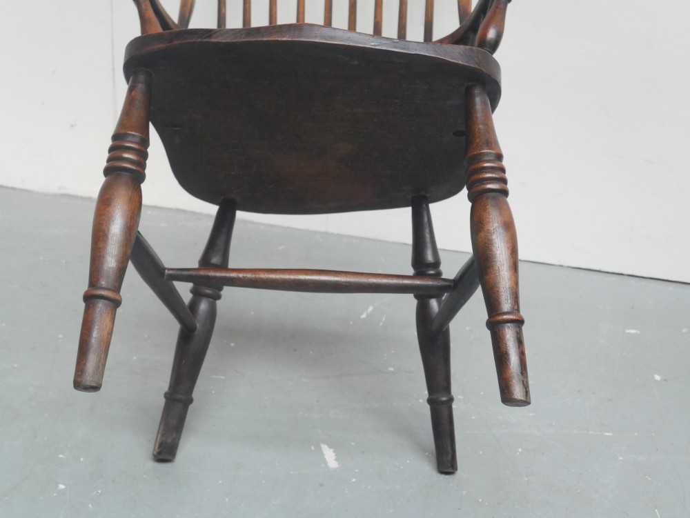 A dark brown wooden Windsor armchair featuring a rounded hoop back, vertical spindles, turned legs, and an H-stretcher. View IX