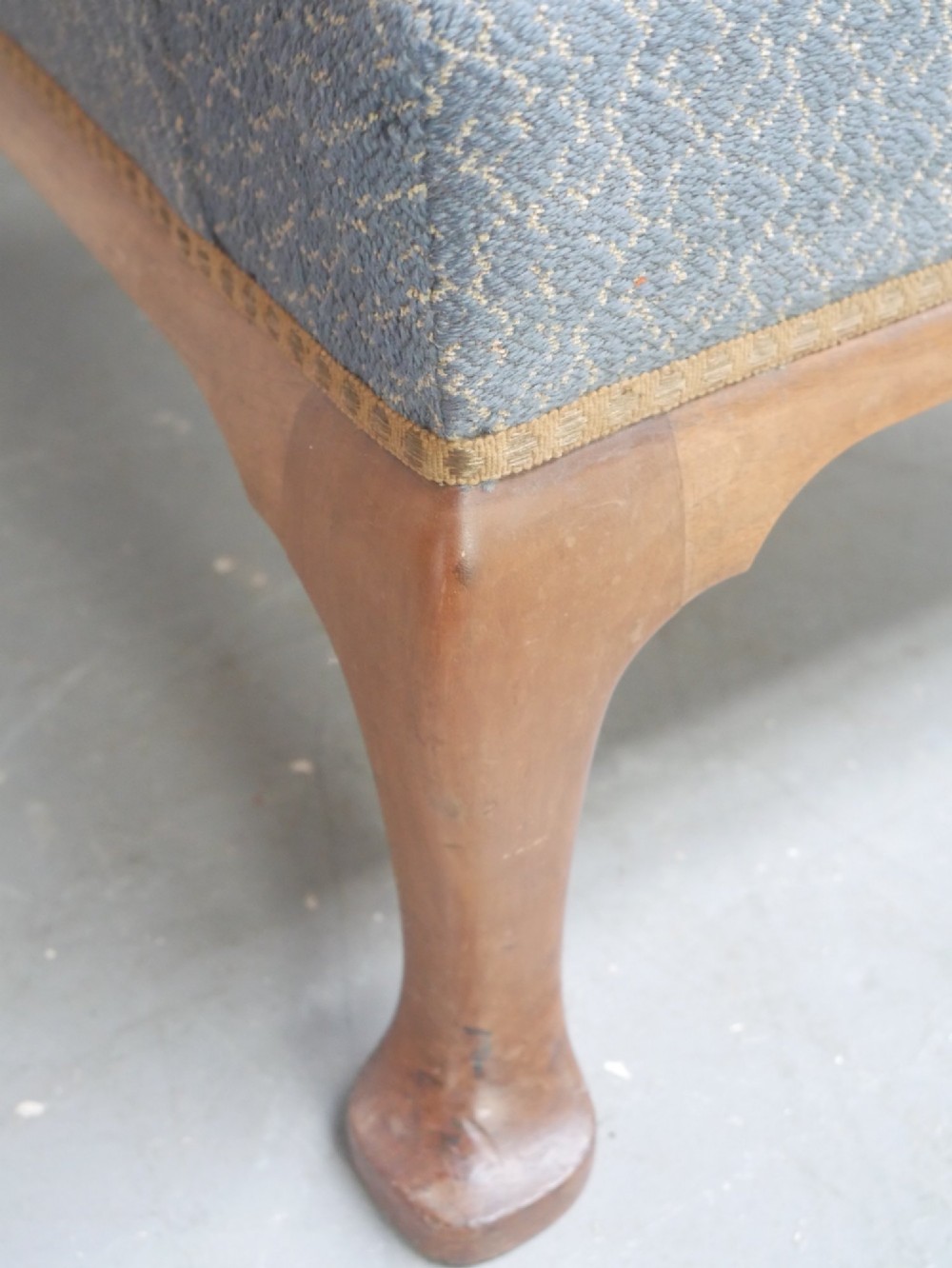 A Scottish wingback armchair upholstered in patterned slate blue fabric featuring mahogany cabriole front legs and brass stud detailing along the lower frame. View II