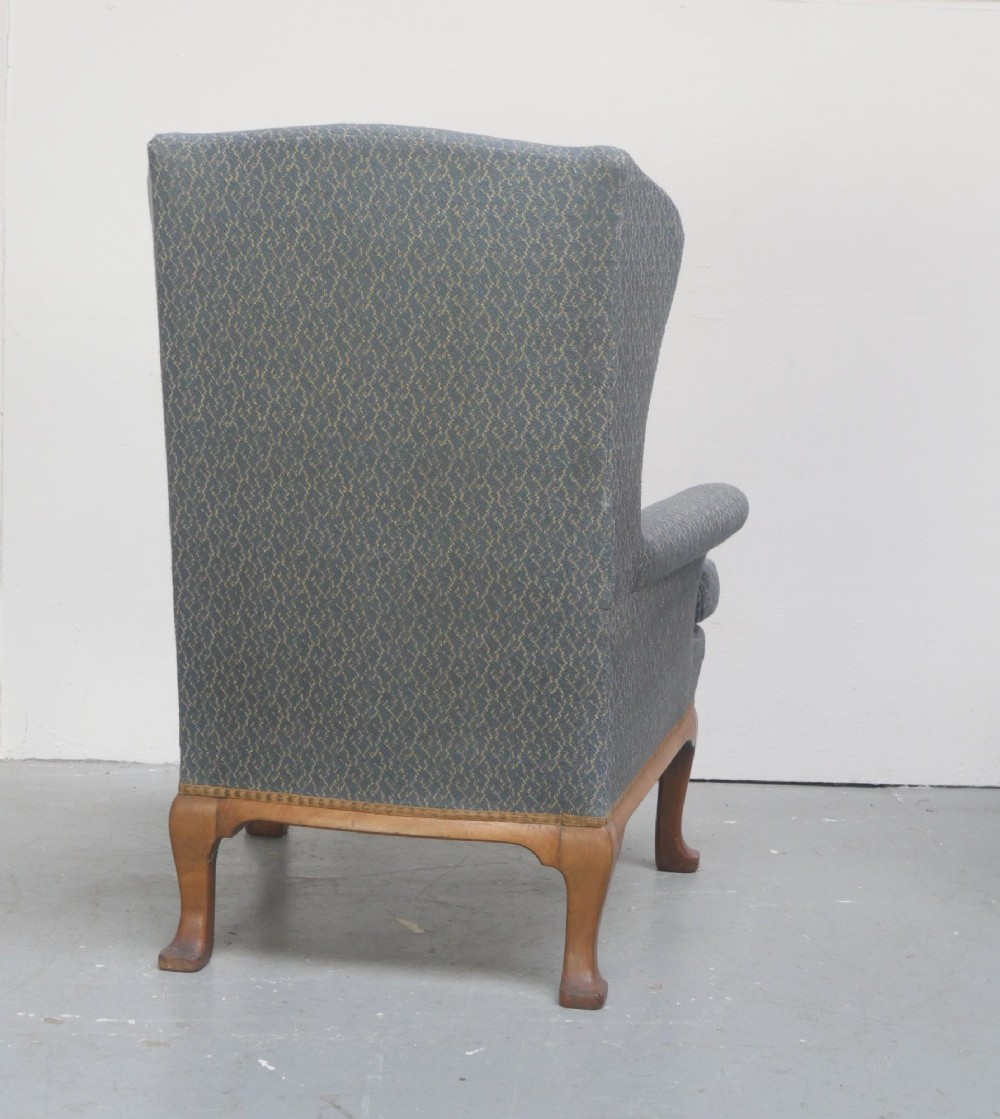 A Scottish wingback armchair upholstered in patterned slate blue fabric featuring mahogany cabriole front legs and brass stud detailing along the lower frame. View VIII