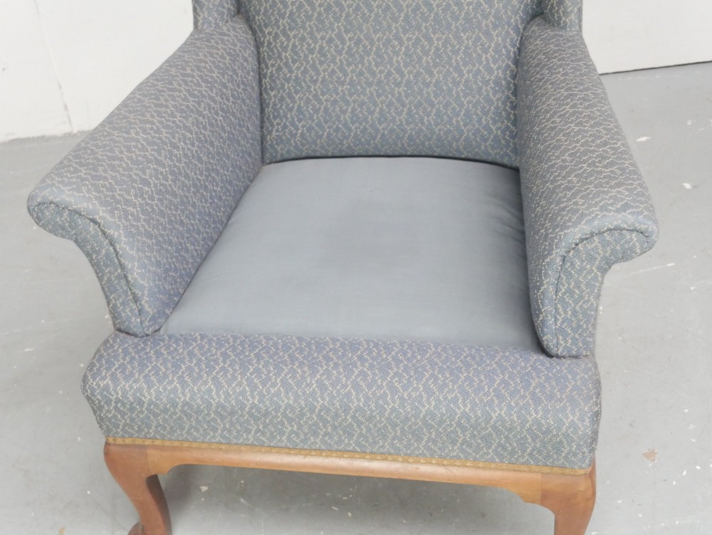 A Scottish wingback armchair upholstered in patterned slate blue fabric featuring mahogany cabriole front legs and brass stud detailing along the lower frame. View IX