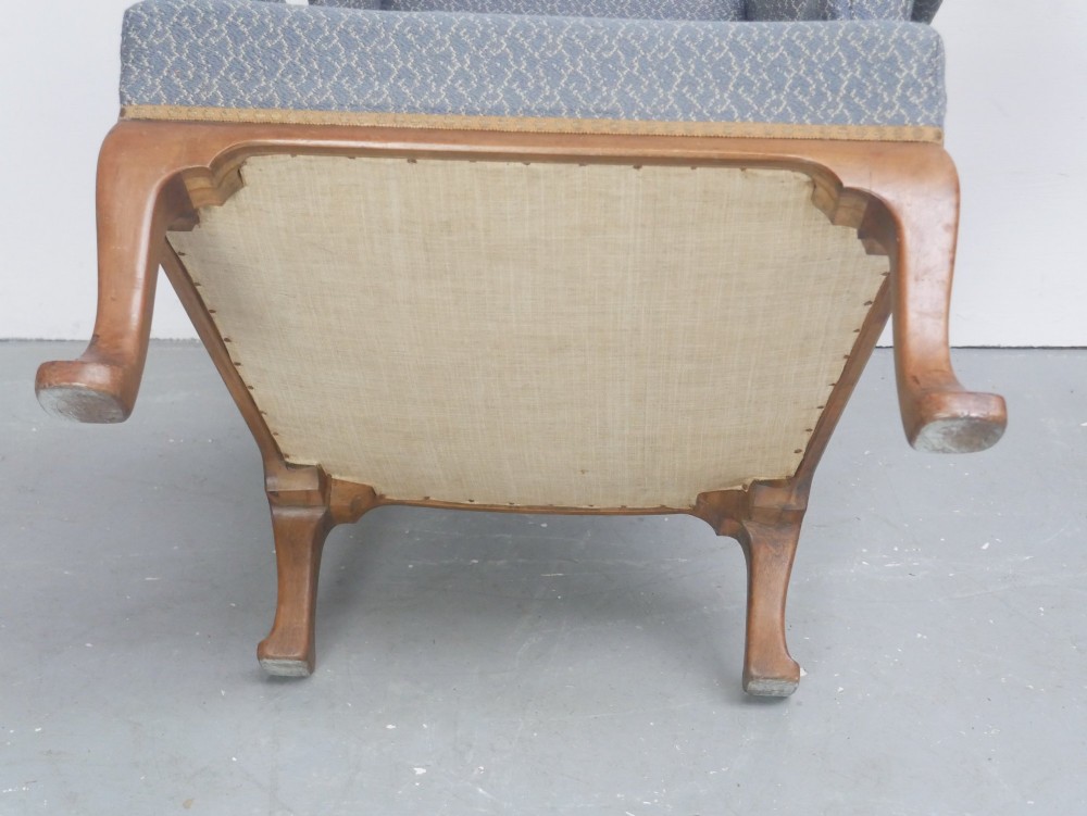 A Scottish wingback armchair upholstered in patterned slate blue fabric featuring mahogany cabriole front legs and brass stud detailing along the lower frame. View XI
