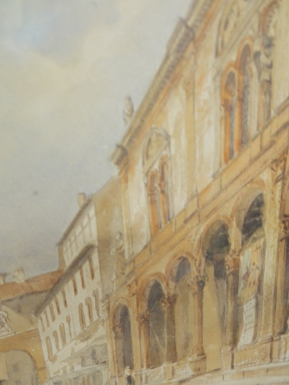 A framed 19th-century watercolour painting depicting a historic Italian piazza with an ornate tower, arched arcade, and market figures. View IV