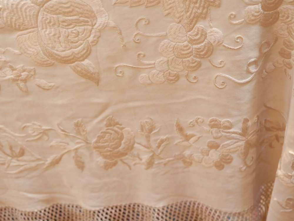 A cream-coloured silk piano shawl featuring tonal floral hand embroidery and deep knotted fringe edge. View VI