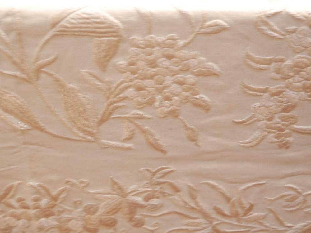 A cream-coloured silk piano shawl featuring tonal floral hand embroidery and deep knotted fringe edge. View VII