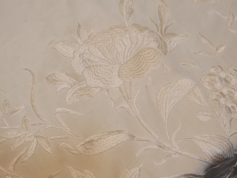 A cream-coloured silk piano shawl featuring tonal floral hand embroidery and deep knotted fringe edge. View IX