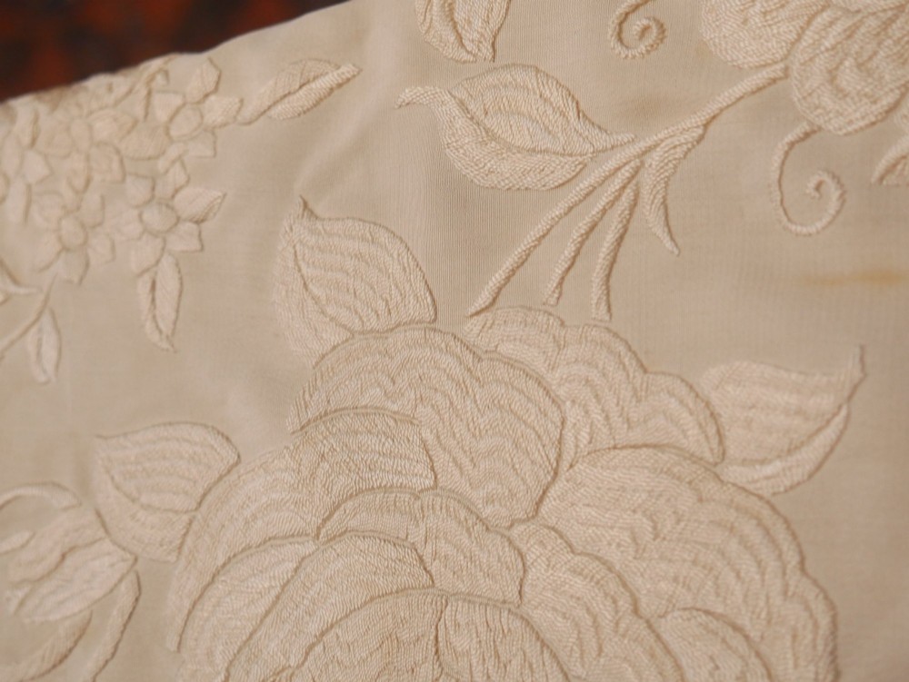 A cream-coloured silk piano shawl featuring tonal floral hand embroidery and deep knotted fringe edge. View XI