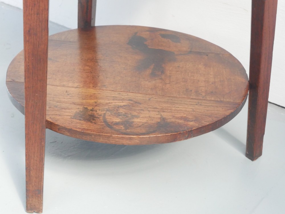 An antique oak cricket table featuring a circular top, three splayed legs, a triangular apron, and a lower circular undertier. View IV