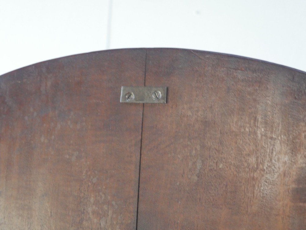 An antique Regency oval mahogany tilt-top table shown upright on a splayed pedestal base with brass castors. View IX