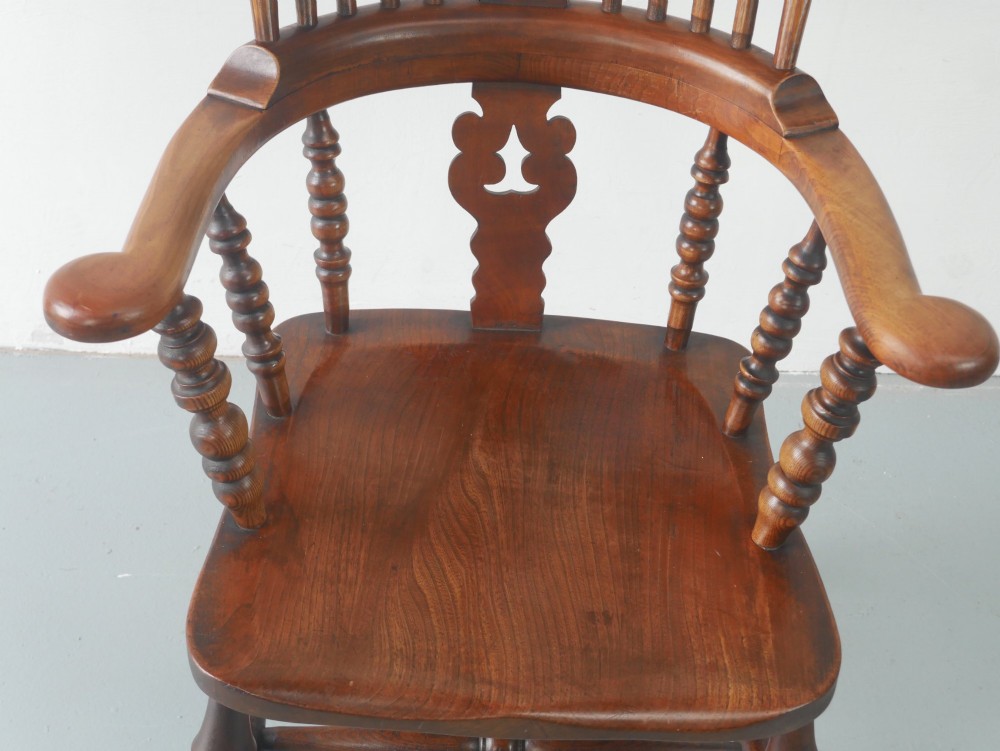 A wooden broad-arm Windsor armchair featuring a hoop back, pierced central splat, turned spindles, and a saddle seat. View III