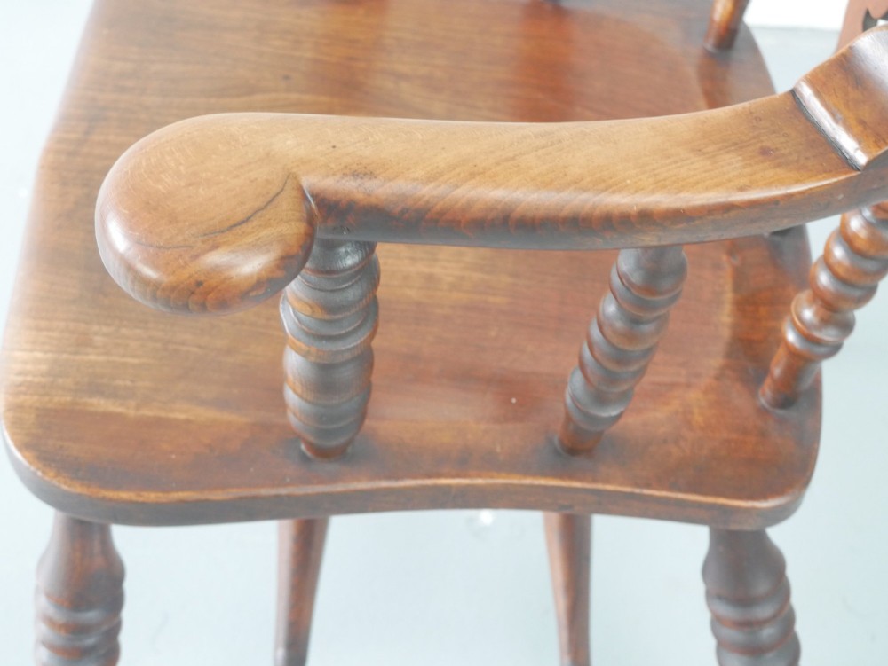 A wooden broad-arm Windsor armchair featuring a hoop back, pierced central splat, turned spindles, and a saddle seat. View VII