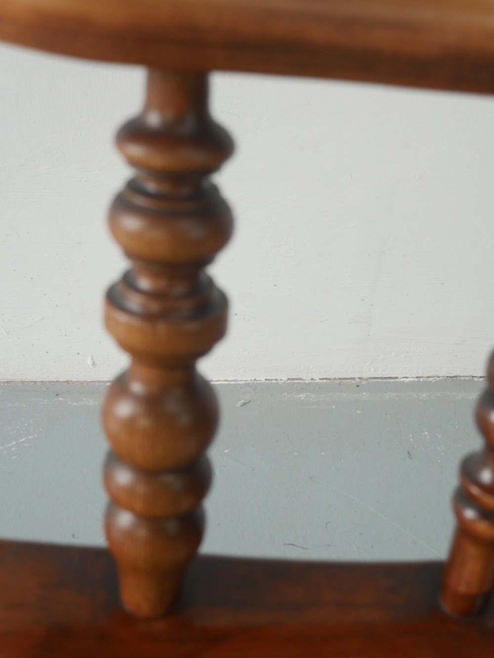 A wooden broad-arm Windsor armchair featuring a hoop back, pierced central splat, turned spindles, and a saddle seat. View VIII