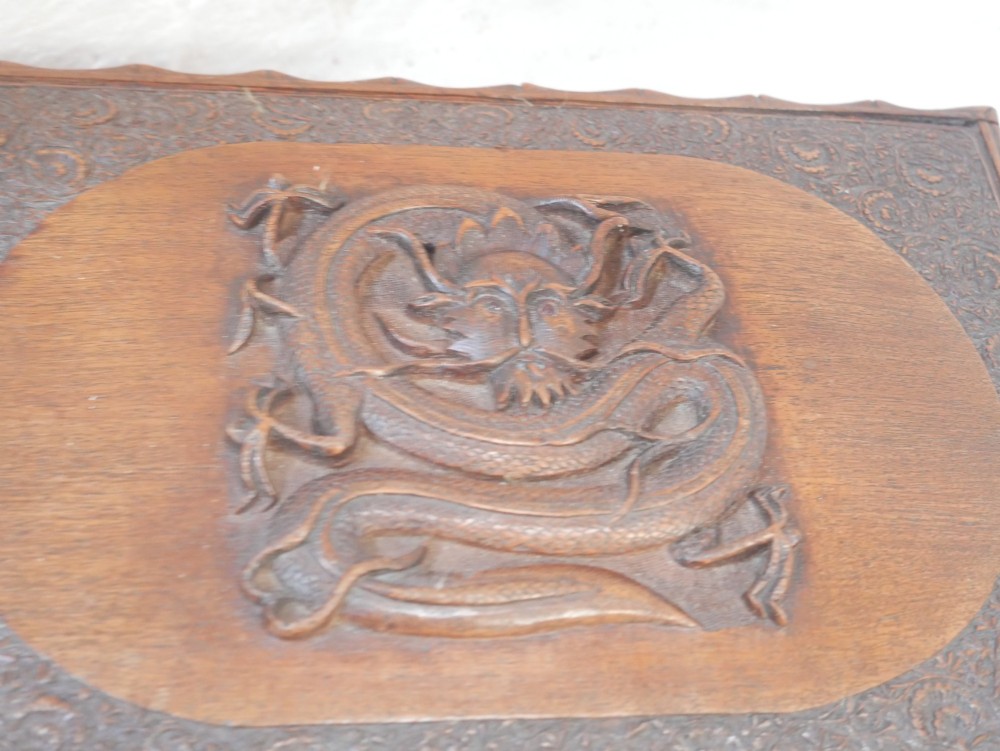 A rectangular Anglo-Indian carved teak box featuring a raised central motif on the lid, carved bamboo-style border trim, and side decorative panels. View VI