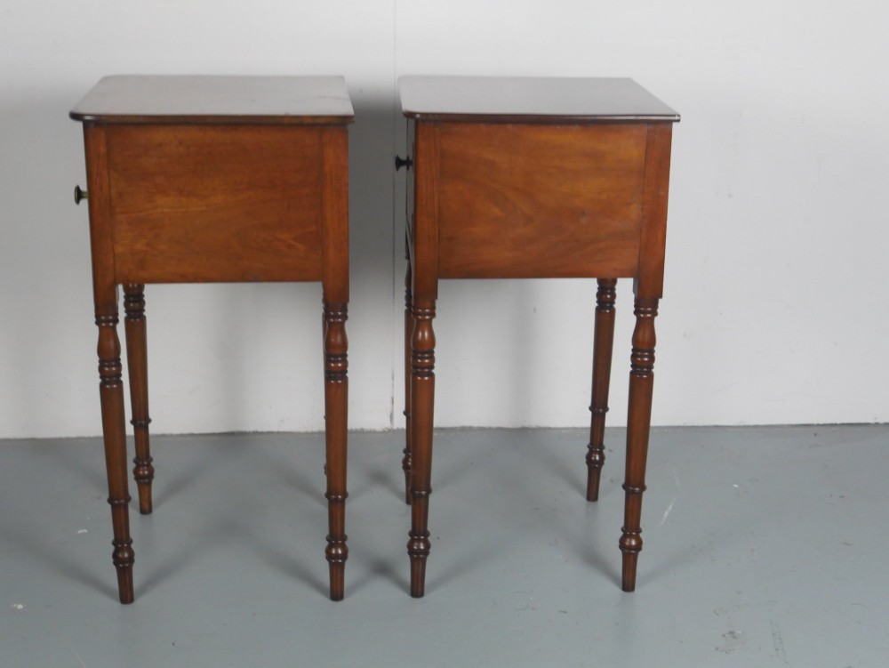 A matching pair of tall mahogany Regency bedside cupboards featuring single panel doors with small handles and slim turned legs. View II