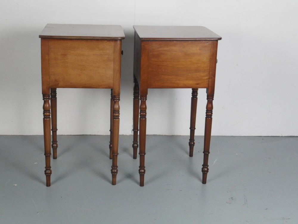 A matching pair of tall mahogany Regency bedside cupboards featuring single panel doors with small handles and slim turned legs. View IV