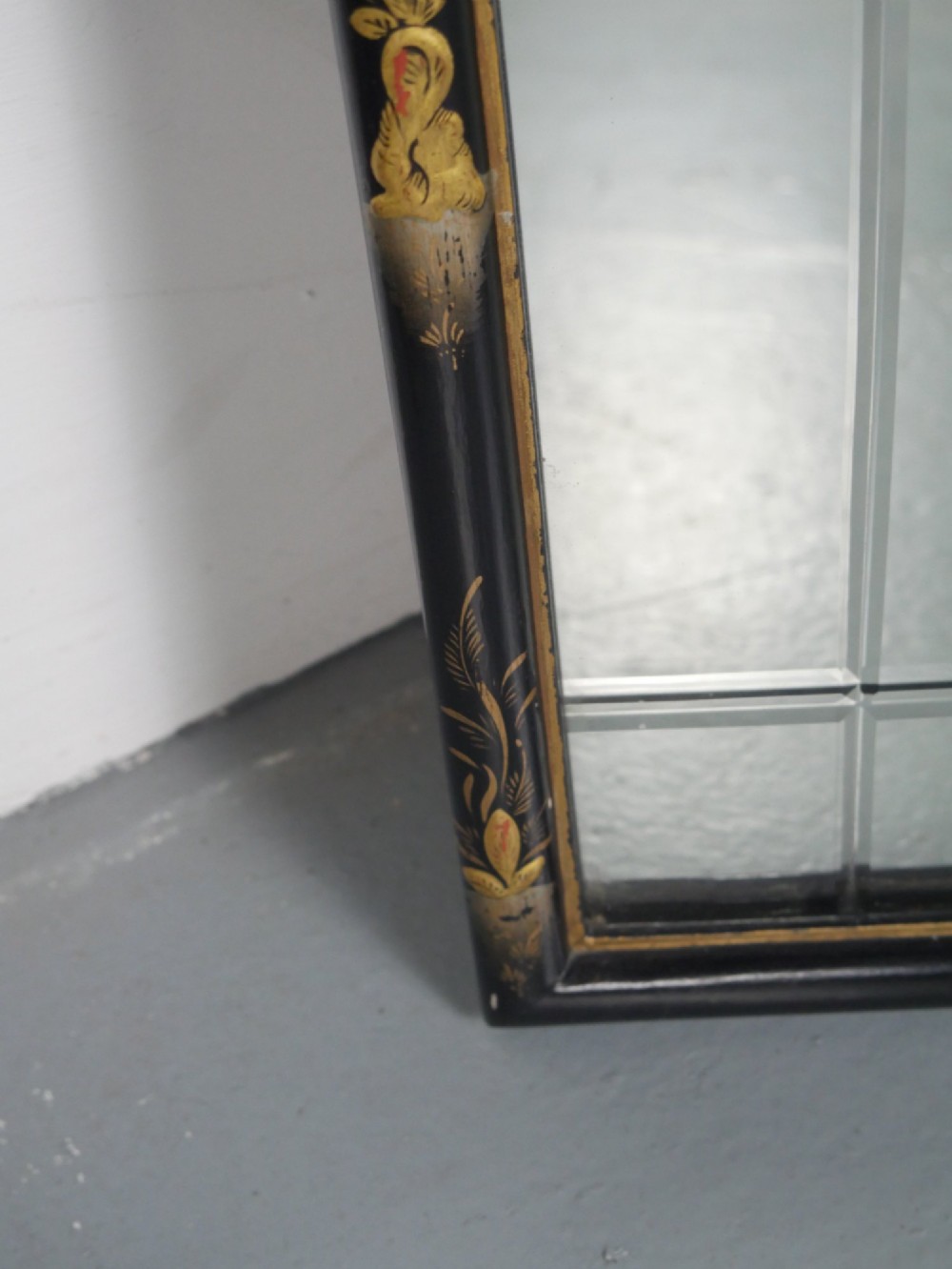 An arched black lacquer wall mirror decorated with gold hand-painted chinoiserie details and sectioned bevelled glass. View VI