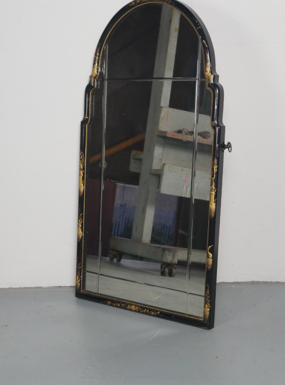 An arched black lacquer wall mirror decorated with gold hand-painted chinoiserie details and sectioned bevelled glass. View VIII