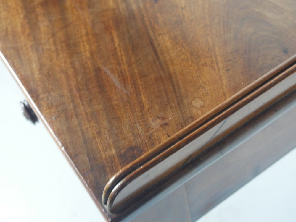 A Regency period mahogany writing table featuring three drawers with wooden knobs, a three-sided gallery rim, and four reeded legs. View XI