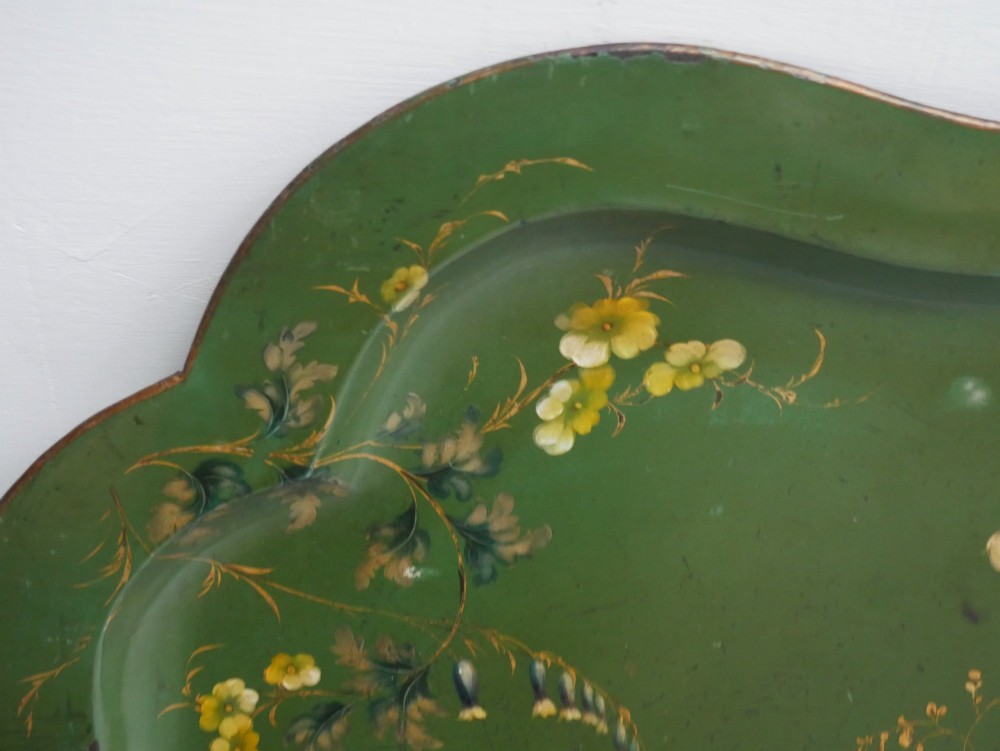 An antique 19th-century olive green painted metal toleware tray featuring a scalloped rim and hand-painted botanical flowers with gilded accents. View V