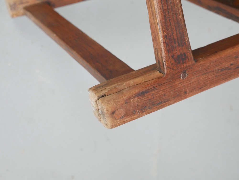 An early 19th-century country oak armchair featuring a high panelled backrest, curved arms, turned front supports, and a square stretcher base. View X
