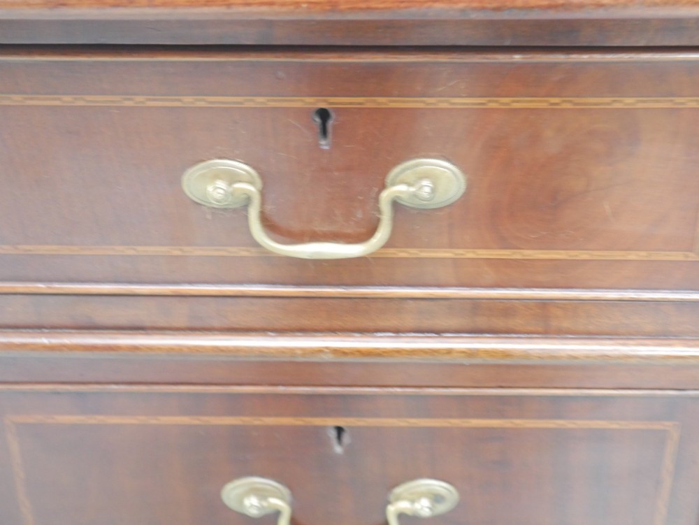 An Edwardian mahogany kneehole pedestal desk featuring an inset writing top, inlaid drawer borders, and nine drawers fitted with brass swan-neck handles. View XII
