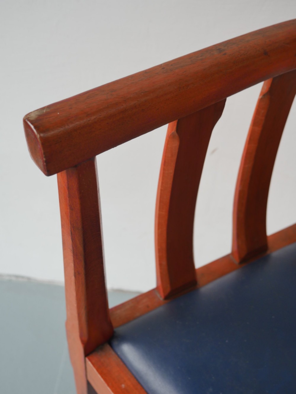 A pair of warm brown hardwood tub armchairs featuring curved slatted backrests and navy blue upholstered seats. View IV
