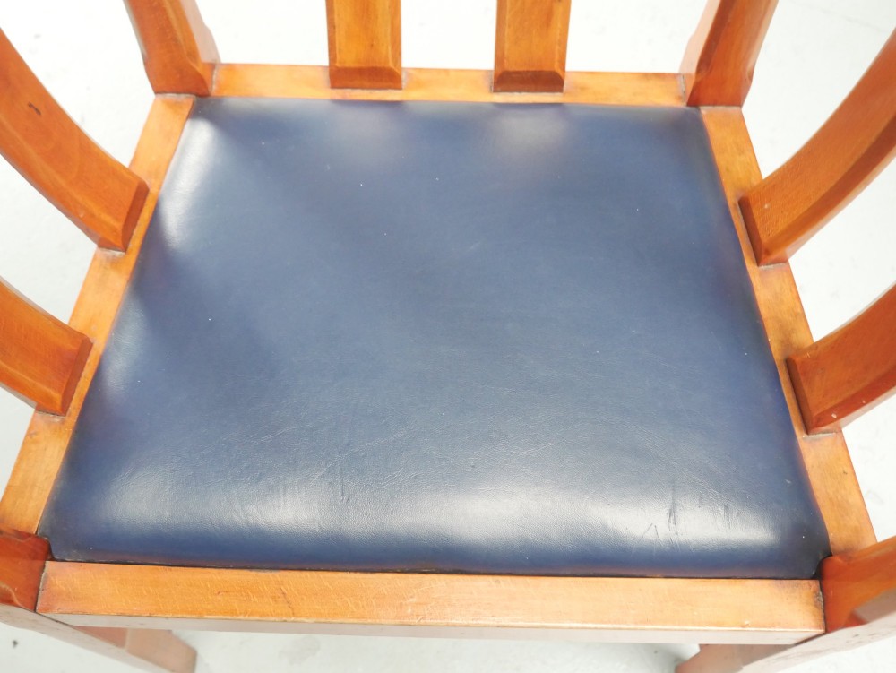 A pair of warm brown hardwood tub armchairs featuring curved slatted backrests and navy blue upholstered seats. View VI