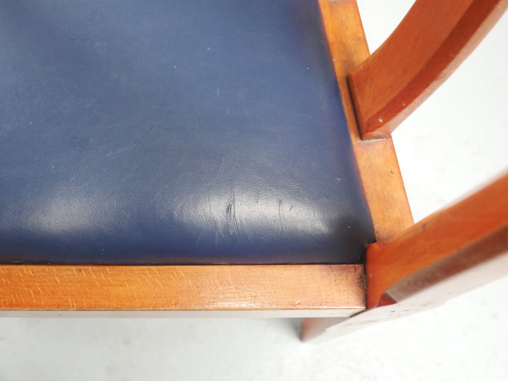 A pair of warm brown hardwood tub armchairs featuring curved slatted backrests and navy blue upholstered seats. View VII