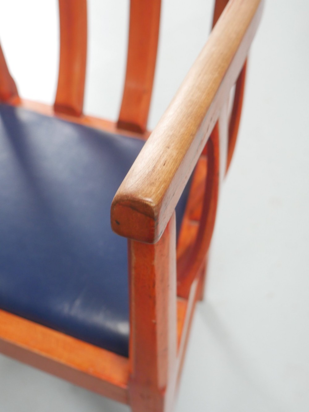 A pair of warm brown hardwood tub armchairs featuring curved slatted backrests and navy blue upholstered seats. View VIII