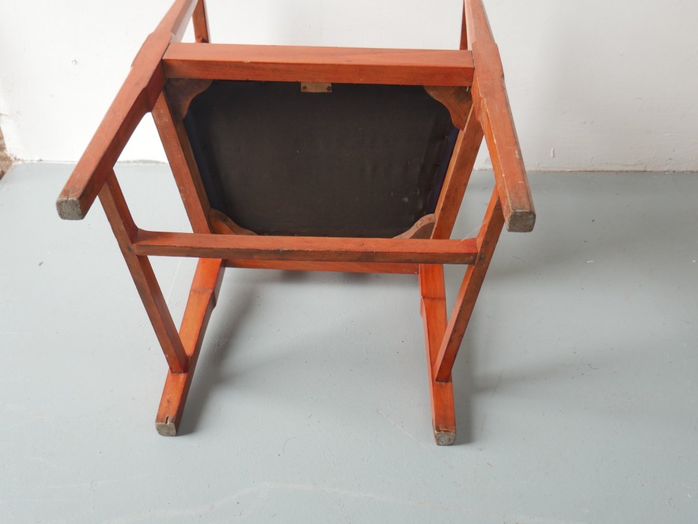 A pair of warm brown hardwood tub armchairs featuring curved slatted backrests and navy blue upholstered seats. View IX