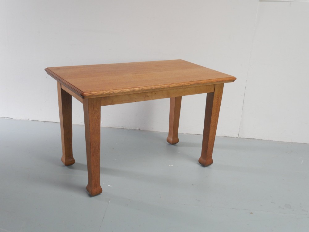 A rectangular solid oak kitchen dining table featuring shaped legs and a moulded edge top.