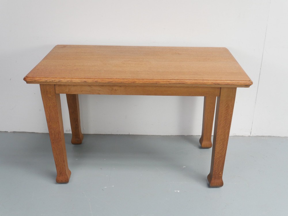 A rectangular solid oak kitchen dining table featuring shaped legs and a moulded edge top. View II