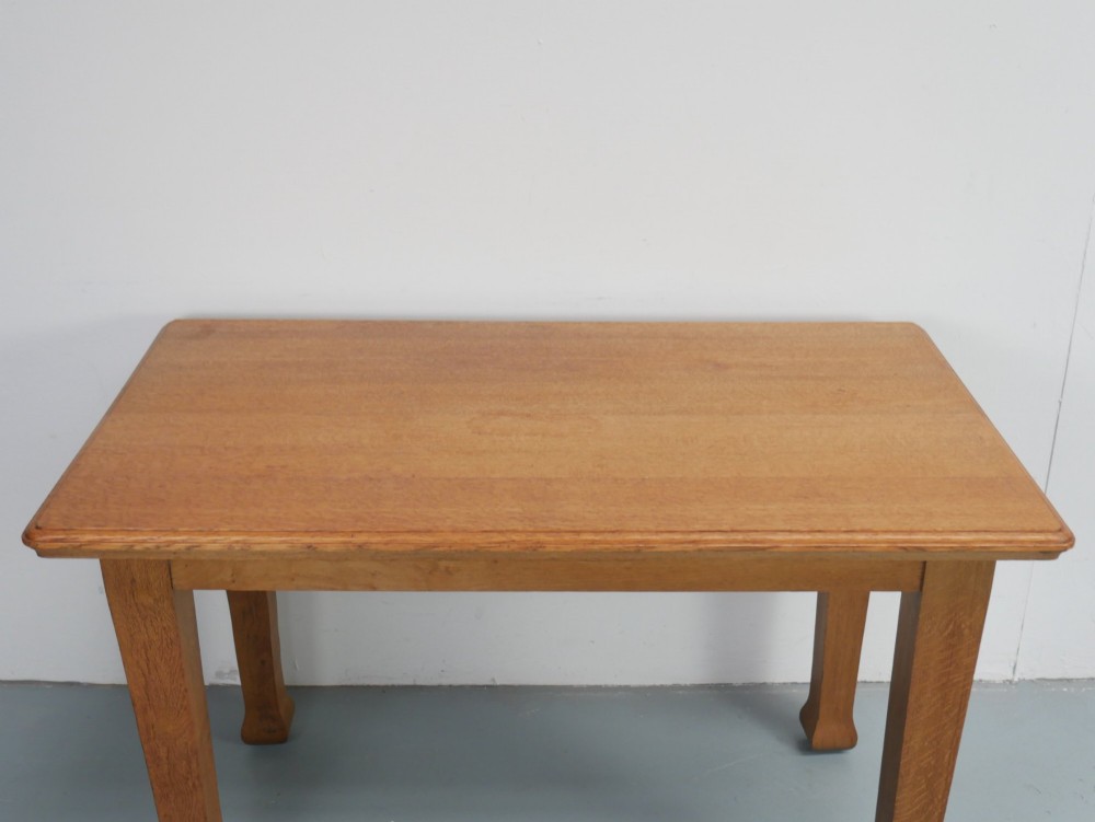 A rectangular solid oak kitchen dining table featuring shaped legs and a moulded edge top. View III
