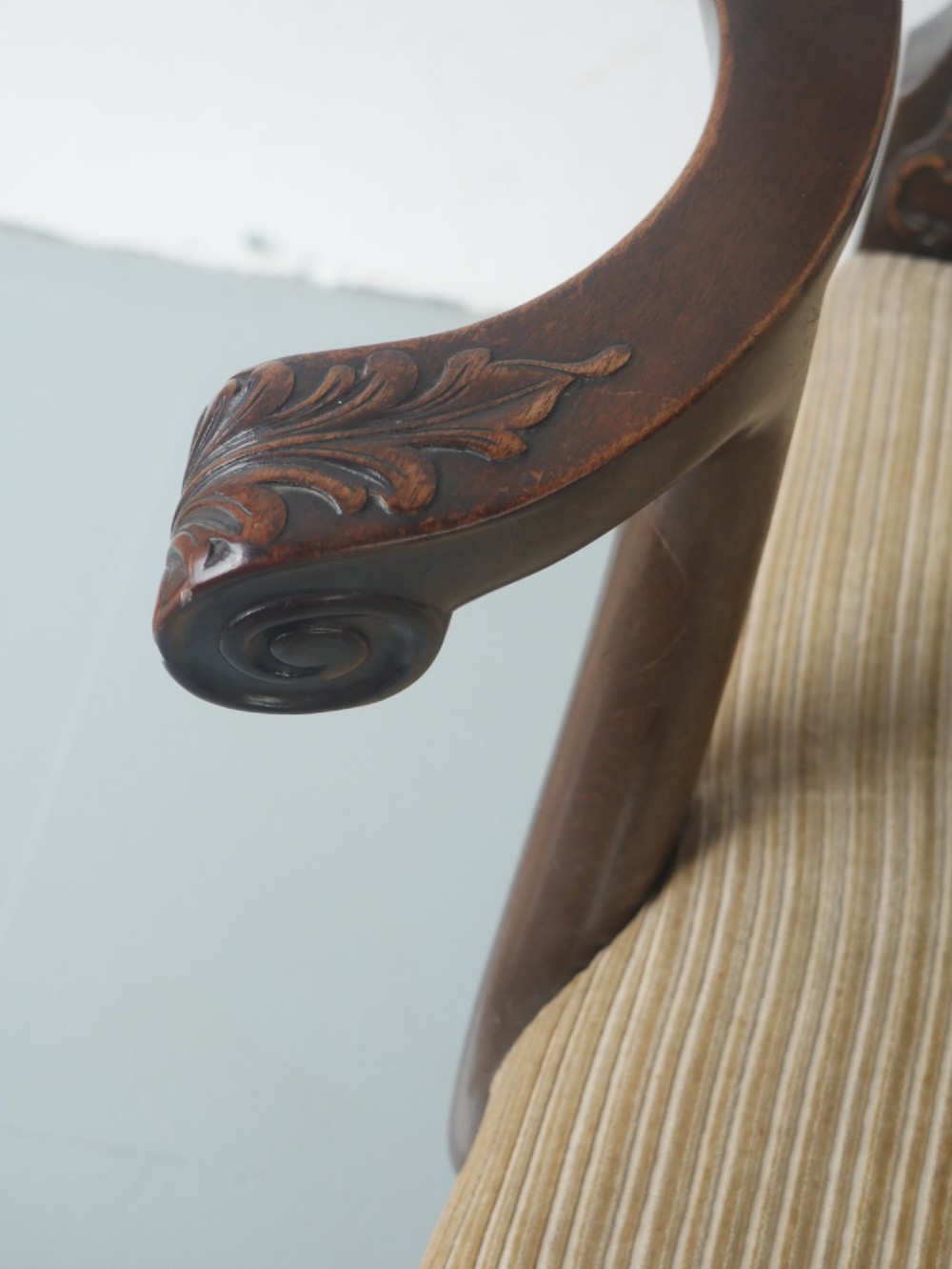 A carved mahogany armchair featuring an ornate pierced splat back, scrolled arms, tan striped fabric upholstery, and cabriole front legs with claw-and-ball feet. View IX